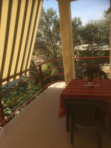 a table on the balcony of a house with a view at H and H Guesthouse in Velipojë