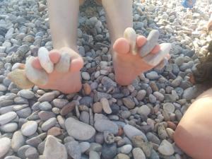 a person with their feet in the rocks at Apartment Nono Ivo in Vis