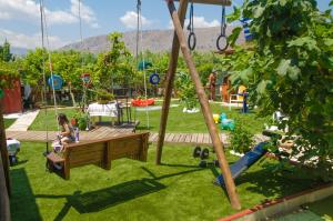 a woman sitting on a swing in a playground at Ideal Studios in Amoudara Herakliou