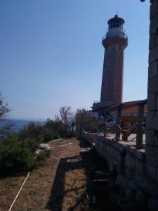 a lighthouse sitting on top of a hill at Apartment Nono Ivo in Vis