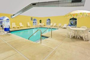 a pool with a table and chairs and a table and a table and chairsktop at Microtel Inn & Suites by Wyndham Prairie du Chien in Prairie du Chien