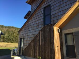 una casa con una pared de madera y una puerta en GITES SAINT ROMARY, en Saint-Étienne-lès-Remiremont
