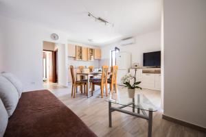 een woonkamer met een tafel en stoelen en een keuken bij Apartments Bongavila in Podstrana