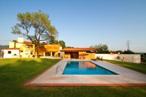 a swimming pool in the yard of a house at Quinta de Lograssol in Mealhada
