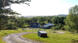 a dirt road leading to a farm with a building at Row Farm Cottage in Millom