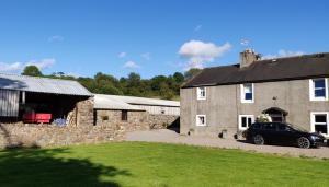 a car parked in front of a stone building at Row Farm Cottage in Millom