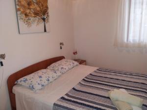 a small bedroom with a bed with a blanket on it at Apartment Nono Ivo in Vis