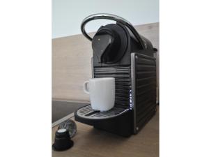 a coffee maker with a cup on a stand at Ferienwohnung Moselufer Zell in Zell an der Mosel