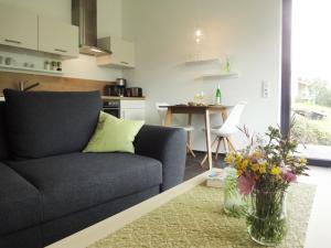 a living room with a couch and a table with flowers at Ferienwohnung Moselufer Zell in Zell an der Mosel