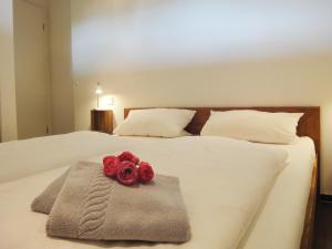 a bed with two red roses on top of it at Ferienwohnung Moselufer Zell in Zell an der Mosel
