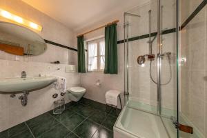 uma casa de banho com um WC com lavatório e um chuveiro em Almroeserl em Mittenwald