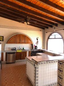eine große Küche mit Holzschränken und einer Arbeitsplatte in der Unterkunft Ocean Front Antique House, Private Beach! in Rosarito