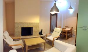 a living room with a fireplace and white chairs at Alba Pura in Santa Caterina Dello Ionio Marina