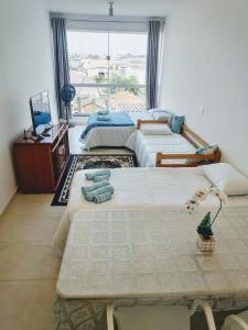 drie bedden in een kamer met een raam bij Sky S House in Sao Paulo