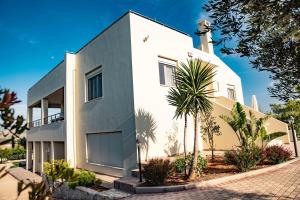 Una casa blanca con un faro encima. en Luxury Villa Marilena, en Epáno Váthia