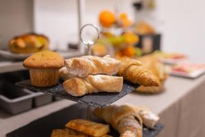 a tray of pastries and muffins on a counter at Al Qatta Bed & Breakfast in Canicattì