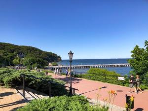 people walking on a sidewalk near the water with a pier at Pokoje Gościnne Przy Molo in Gdynia