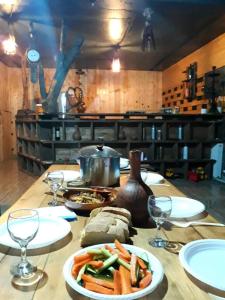 a wooden table with plates of food and wine glasses at HOMEWOOD in Stepantsminda