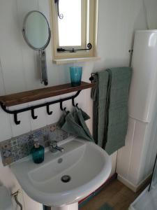 La petite salle de bains est pourvue d'un lavabo et d'un miroir. dans l'établissement The English shepherds hut @ Les Aulnaies, à Échauffour