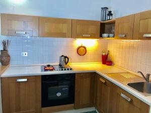 eine Küche mit Holzschränken und einem schwarzen Geschirrspüler in der Unterkunft Appartamento AB in Passo San Pellegrino
