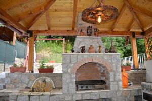 a stone fireplace in a backyard with a wooden ceiling at Villa Marija in Ohrid
