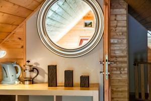 a circular mirror above a counter in a kitchen with a window at Leśniczówka WIEŻYCA in Szymbark +180 photos