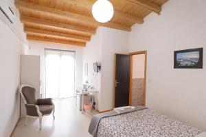 1 dormitorio con 1 cama y 1 silla en Al Qatta Bed & Breakfast, en Canicattì