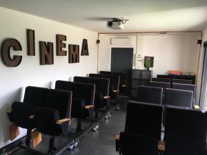 a conference room with black chairs and the word cinema on the wall at Villa Charles & Ashton in Sarzeau