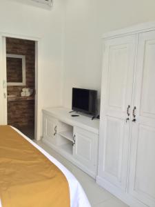 a bedroom with a bed and a tv on a cabinet at Queen Guest house tulamben in Tulamben