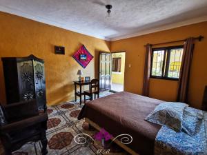 a bedroom with a bed and a table and a window at Maison Bougainvillea in Antigua Guatemala