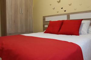 a red bed with red pillows in a bedroom at Casa do Roxo de Rinlo Nº REGISTRO VUT-LU-00706 in Rinlo