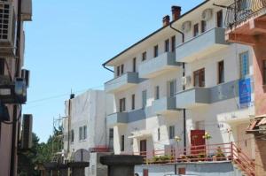 a large white building with a balcony on a street at Kings Apartment 4 in Kolgecaj +4 photos