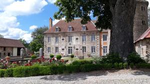 ein großes Steingebäude mit Blumen davor in der Unterkunft gîte au Château de Sallebrune in Beaune dʼAllier