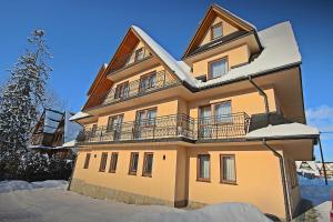 a large house with snow on it at Dom Wczasowy " U Józefa " in Zakopane