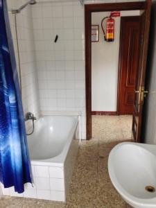 y baño con bañera, aseo y lavamanos. en Pensión Glorioso Hostel en Picaraña