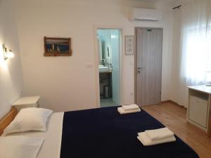 1 dormitorio con 1 cama con 2 toallas en Golden B&B, en Split