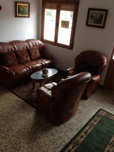 una sala de estar con 2 sofás de cuero y una mesa. en Hostel Glorioso, en Picaraña
