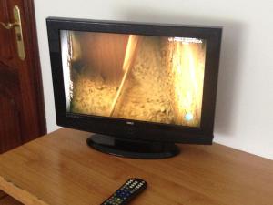 a television sitting on a table with a remote control at Pensión Glorioso Hostel in Picaraña