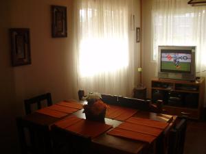 薩爾塔的住宿－Cabaña la linda Vaqueros，一间带桌子和电视的用餐室