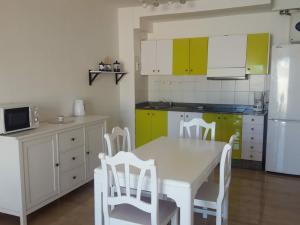 cocina con mesa blanca y sillas blancas en Apartamentos Tahiche, en Costa Teguise