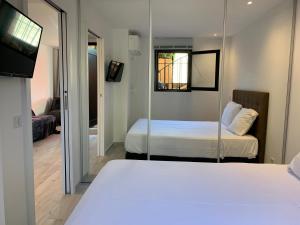 sypialnia z 2 łóżkami i lustrem w obiekcie Marines appartement, 2min plage, 2km Saint-Tropez w mieście Cogolin