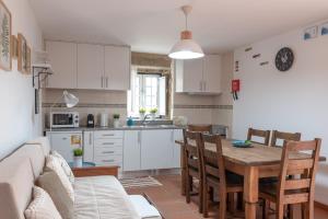 a kitchen and living room with a table and a couch at Casa dos Cortes in Sever do Vouga