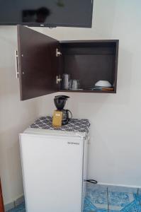 Cette chambre comprend un petit réfrigérateur blanc et une étagère. dans l'établissement Posada Paso Del Sol, à Isla Mujeres