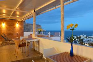 einen Balkon mit einem Tisch und Stühlen sowie Meerblick in der Unterkunft Bella Vista Sun Club in Puerto de Mogán