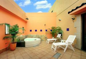 a patio with a hot tub and two chairs at ホテル イコイ in Kawaguchi