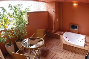 ein Badezimmer mit einer Badewanne, einem Tisch und Pflanzen in der Unterkunft HOTEL IKOI (Adult Only) in Kawaguchi