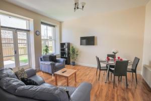a living room with a couch and a table at Stylish Modern 4 Bed Apartment in Edinburgh