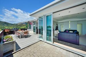 an open deck with a couch and a table at Aporo Nelson Holiday Home in Nelson