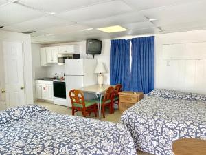 a room with two beds and a table and a kitchen at White Caps Motel in North Wildwood