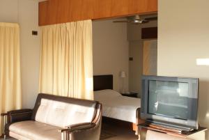 sala de estar con TV y cama en Departamentos Misiones, en Posadas